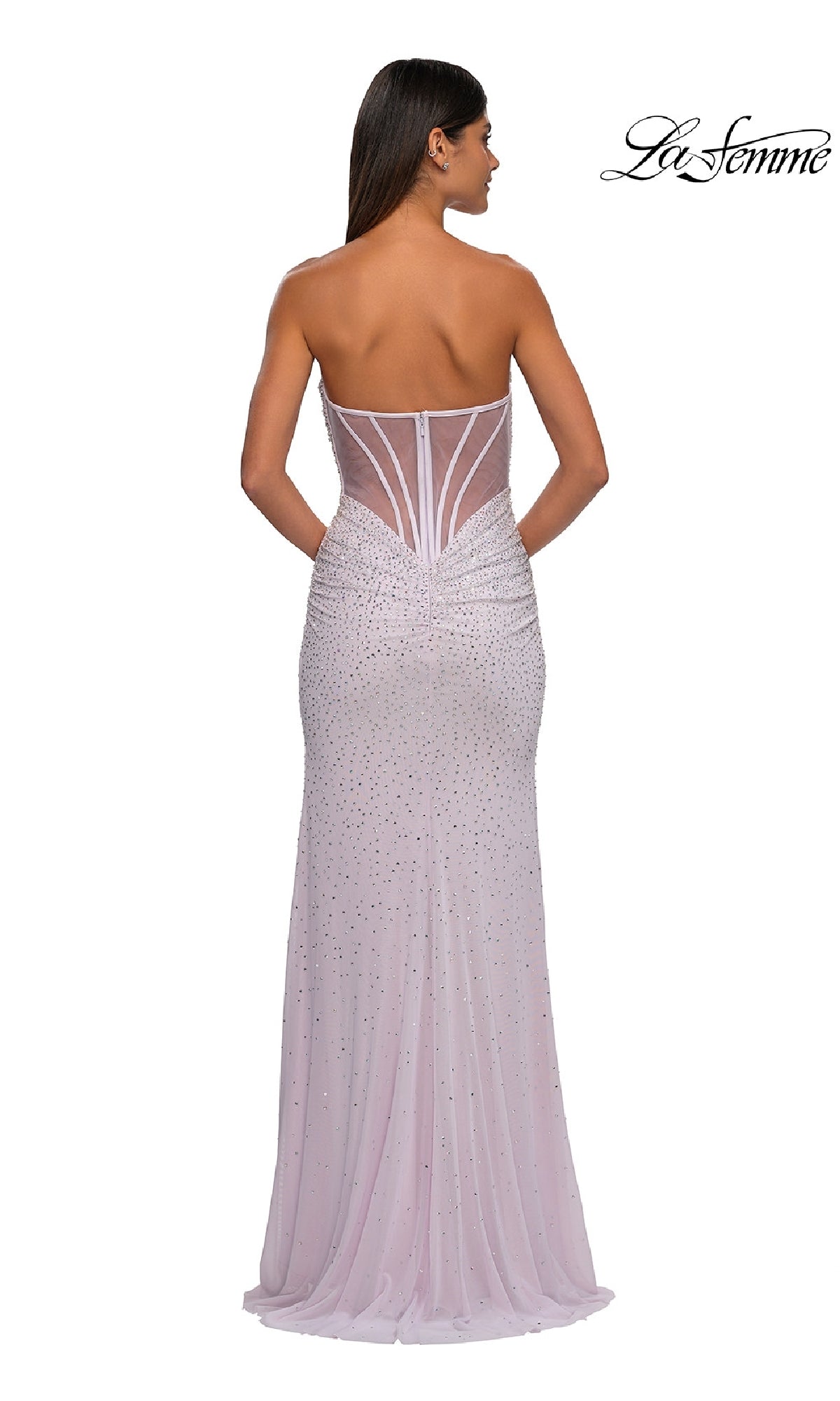 A woman models the Strapless Long Beaded Prom Dress: La Femme 32774 in light pink with sheer paneling and delicate embellishments, photographed from the back. The La Femme prom dress logo is in the top right corner.