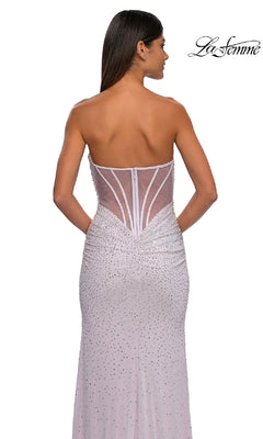 A woman wearing the La Femme 32774 strapless long beaded prom dress in light purple, featuring a sheer back and rhinestone details, faces away from the camera. The "La Femme" logo is shown in the top right corner.