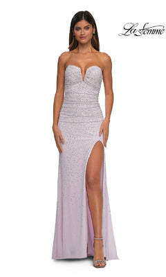 A woman in the La Femme 32774 strapless long beaded prom dress in light lavender, featuring a sweetheart neckline, high slit, and rhinestone details, stands against a white background.