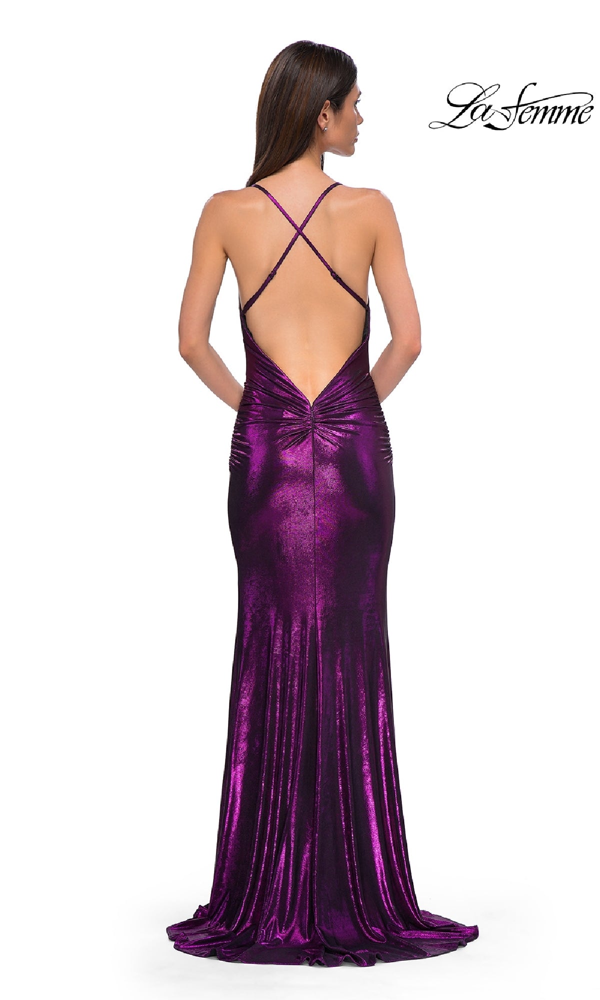A woman faces away wearing the Slinky Long Metallic Prom Dress: La Femme 32782—a shiny purple gown with a low back and crisscross straps. The La Femme logo appears in the top right corner.