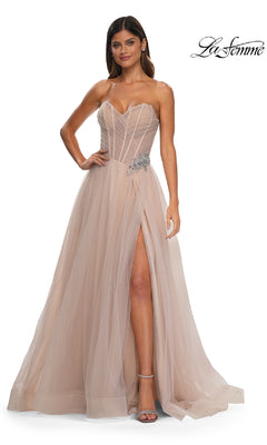 A woman wearing the La Femme 32789 Strapless Long Prom Ball Gown with a sweetheart bodice, sheer nude tulle, thigh-high slit, and rhinestone floral waist detail stands against a white background.