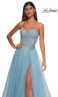 A woman wearing the La Femme 32789 Strapless Long Prom Ball Gown in light blue tulle, featuring a sweetheart bodice, high slit, sheer details, and sparkling rhinestone floral waist accents.