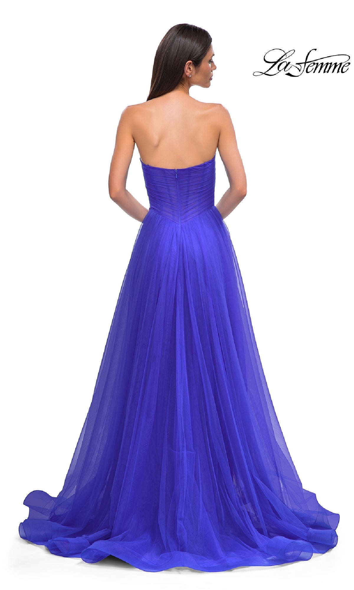A woman is seen from behind in the La Femme 32789 strapless long prom ball gown with a sweetheart bodice and flowing royal blue tulle skirt. The La Femme logo appears in the top right corner.