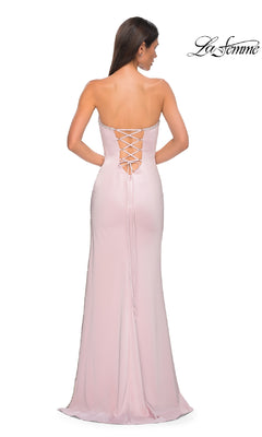 A woman stands with her back to the camera in a light pink, strapless long prom dress featuring a lace-up back—Classic Strapless Long Prom Dress: La Femme 32799. The La Femme logo is displayed in the top right corner.