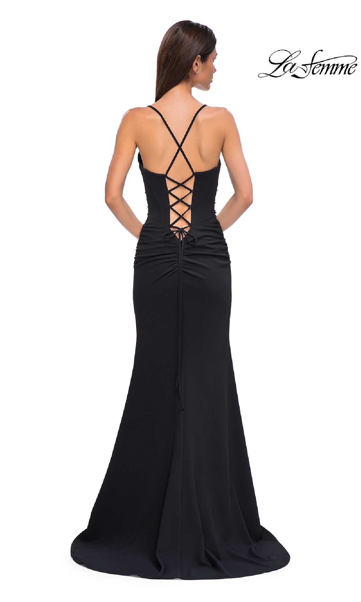 A woman stands against a plain white background wearing the La Femme 32802: a floor-length prom dress featuring a lace-up open back, thin straps, and a fitted silhouette.