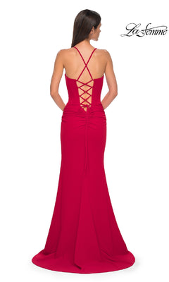 A woman stands with her back to the camera, wearing the La Femme 32802 lace-up open-back long prom dress in red, featuring crisscross straps.