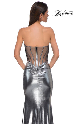 A woman models the Strapless Long Metallic Prom Dress: La Femme 32806, featuring a sheer corset-style back with visible boning, against a white background. The "La Femme" logo is shown in the top right corner.