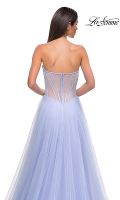 A woman wearing the Strapless Long Prom Ball Gown: La Femme 32811, featuring a light purple beaded sweetheart corset and sheer structured back, stands facing away; the La Femme logo is in the top right corner.