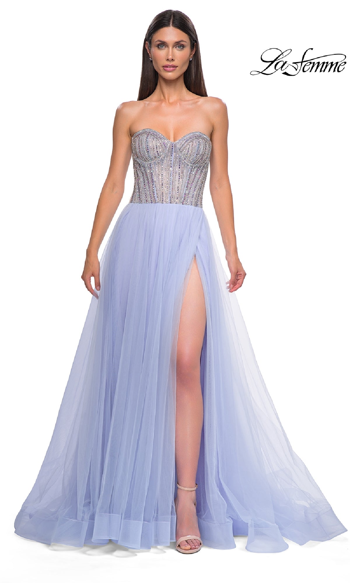 A woman wearing the Strapless Long Prom Ball Gown: La Femme 32811, featuring a beaded corset bodice and high slit, poses against a white background.