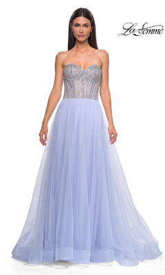 A woman models the Strapless Long Prom Ball Gown: La Femme 32811 in light purple with a beaded sweetheart corset bodice and tulle skirt, standing against a white background. The "La Femme" logo is in the top right corner.
