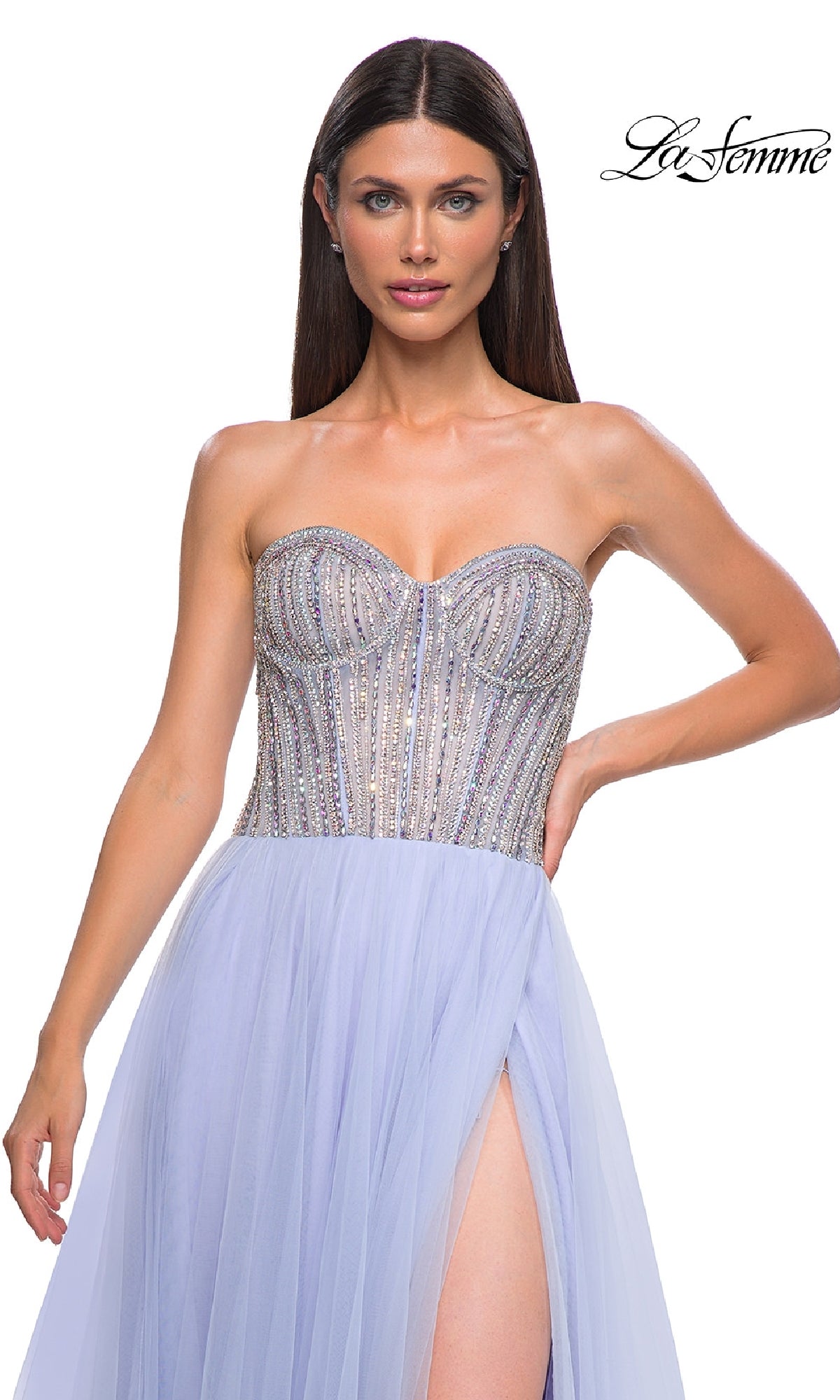 A woman wearing the La Femme 32811 Strapless Long Prom Ball Gown, featuring a beaded sweetheart corset in silver and lavender, tulle skirt, and thigh-high slit, stands against a white background.
