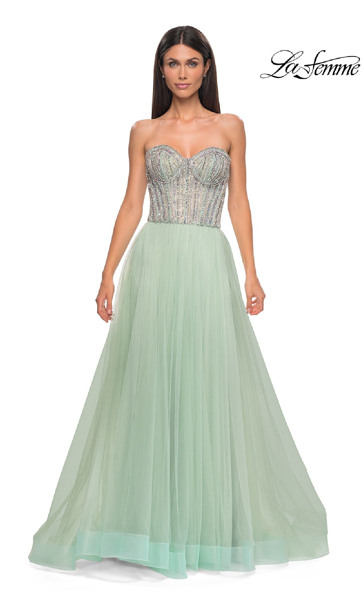 Woman in the Strapless Long Prom Ball Gown: La Femme 32811, featuring a beaded sweetheart corset bodice and flowing light green tulle skirt; 