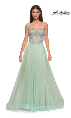 Woman in the Strapless Long Prom Ball Gown: La Femme 32811, featuring a beaded sweetheart corset bodice and flowing light green tulle skirt; "La Femme" logo displayed in the upper right corner.