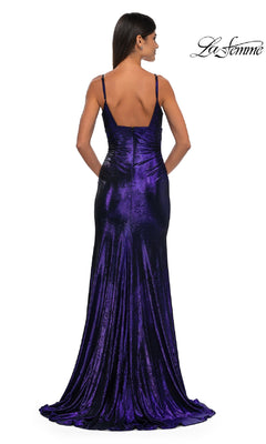 A woman faces away from the camera in the La Femme 32812 V-Neck Long Metallic Prom Dress, a fitted, floor-length designer gown with thin straps, deep purple velvet fabric, and a slight train.