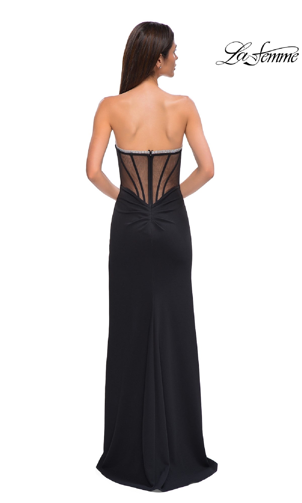 A woman stands facing away, wearing La Femme 32825—a bead-trimmed strapless prom gown with a sheer, structured back and floor-length skirt. The La Femme logo appears in the top right corner.