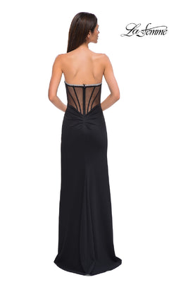 A woman stands facing away, wearing La Femme 32825—a bead-trimmed strapless prom gown with a sheer, structured back and floor-length skirt. The La Femme logo appears in the top right corner.