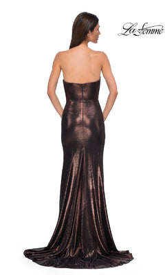 A woman stands with her back to the camera in a strapless long metallic dark brown prom dress with fitted bodice and flowing train, by La Femme. "La Femme 32828" logo appears in the corner.