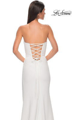 A woman stands against a white background in the La Femme 32829 Lace-Up Strapless Long Prom Dress, showcasing its elegant style and sophisticated lace-up back detail.