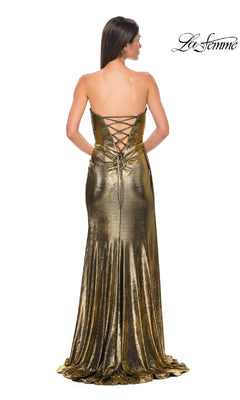Woman modeling the Strapless Long Metallic Prom Dress: La Femme 32830, featuring a lace-up back and floor-length metallic design. She poses with her back to the camera. The "La Femme" logo appears in the top right corner.