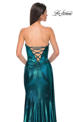A woman models the Strapless Long Metallic Prom Dress: La Femme 32830, a fitted teal gown with a lace-up back, shown from behind. The shimmering dress features a metallic finish, and the La Femme logo appears in the top right corner.