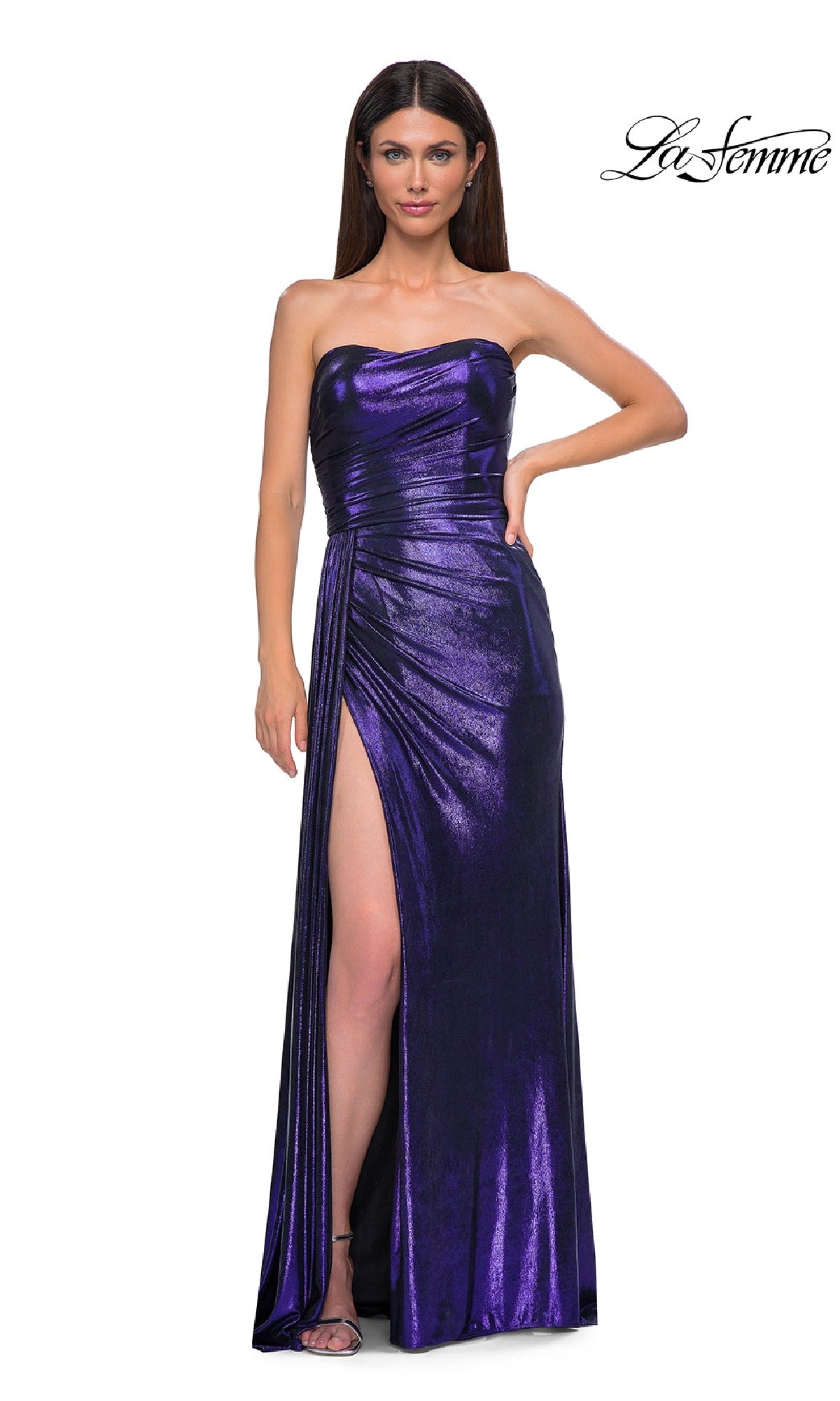 A woman stands confidently with one hand on her hip, modeling the Strapless Long Metallic Prom Dress: La Femme 32830 in striking purple with a thigh-high slit. La Femme logo appears in the top right corner.