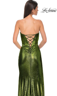 A woman wears the Strapless Long Metallic Prom Dress: La Femme 32830, featuring a metallic finish and lace-up back, standing with her back to the camera. The La Femme logo appears in the top right corner.