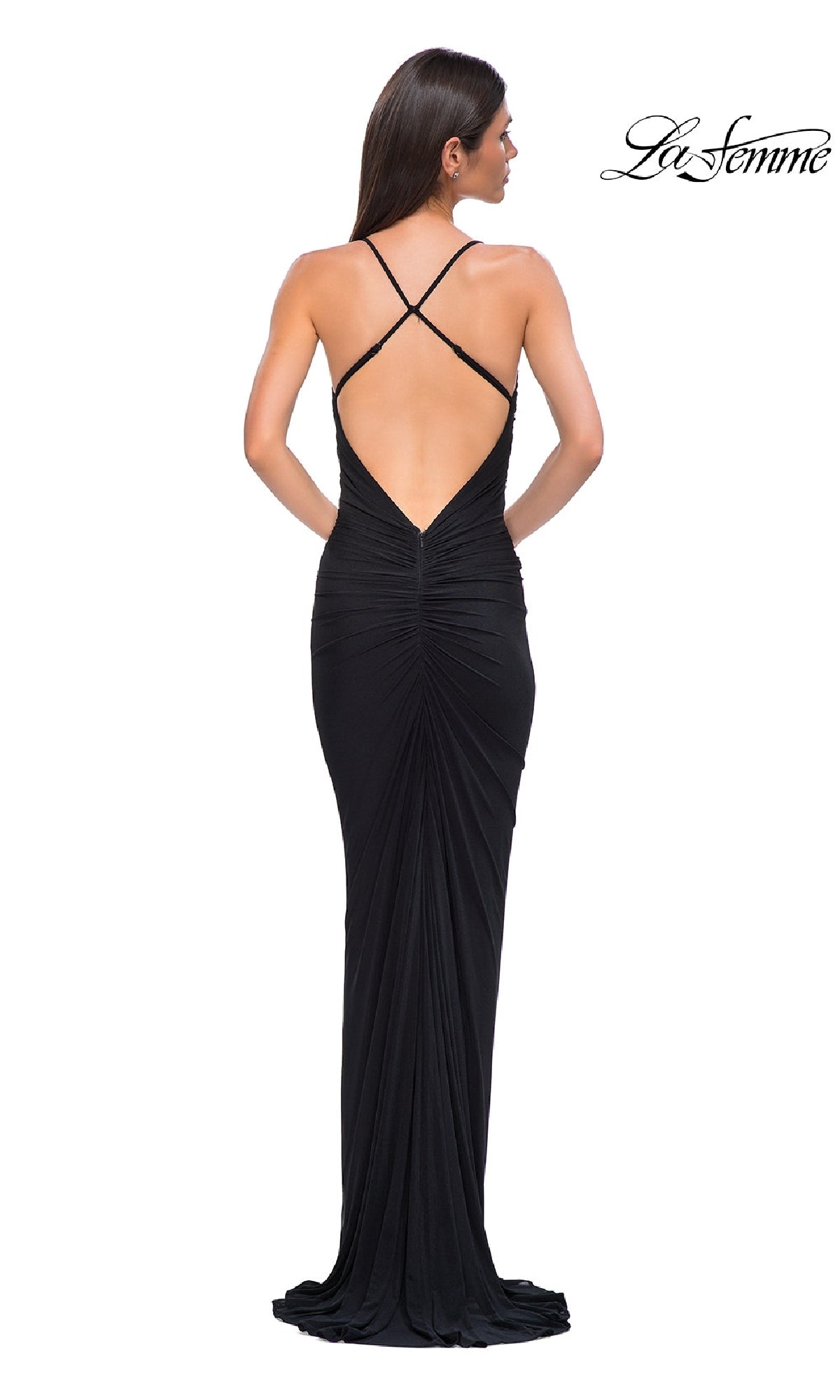 A woman in the La Femme 32834 Deep V-Back Long Prom Dress, featuring a floor-length black design with crisscross straps and a low open back, stands facing away from the camera.