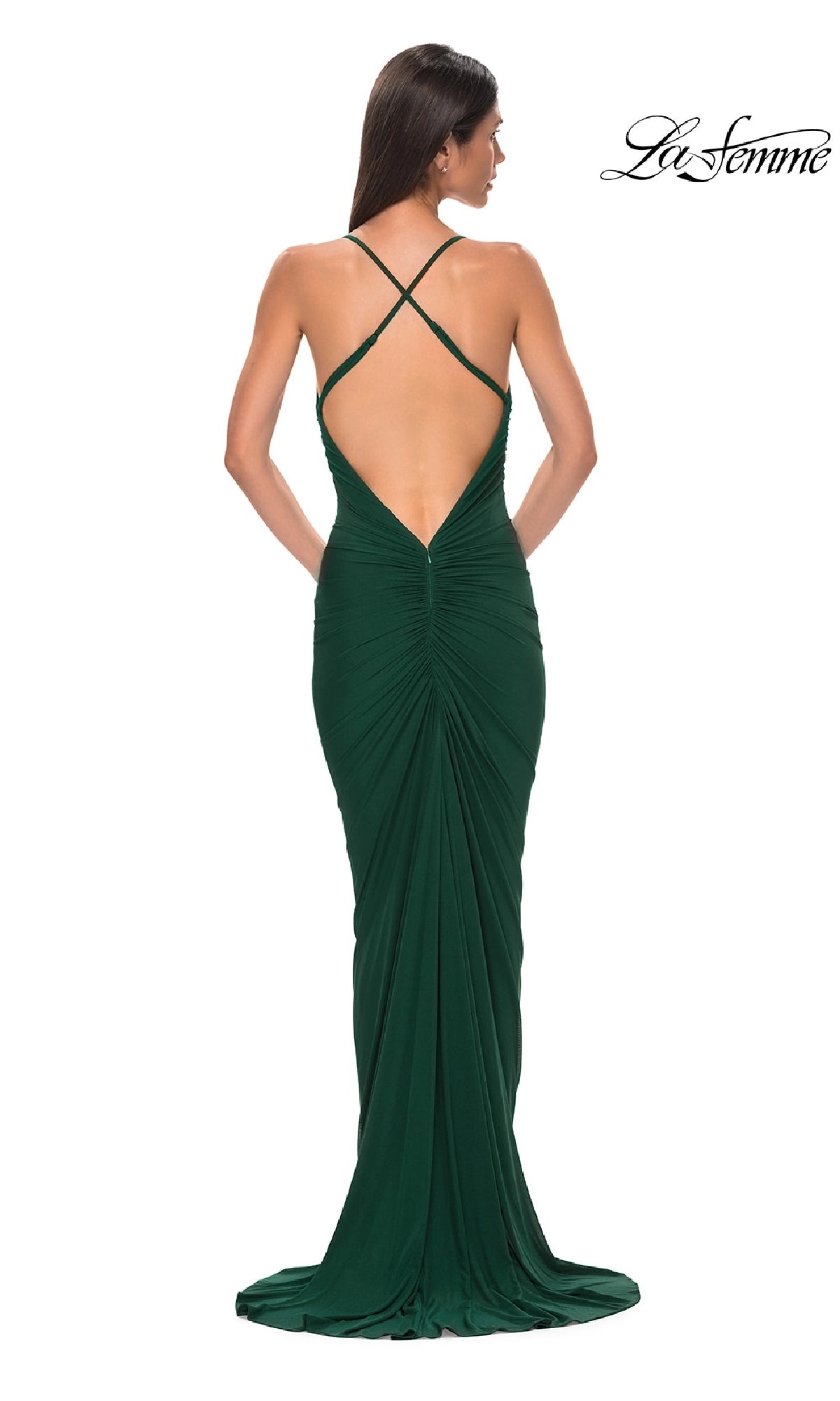 A woman in a dark green Deep V-Back Long Prom Dress, La Femme 32834, is seen from behind wearing her hair down. The backless gown features crisscross straps, ruched design, cowl neck detail, and a slight train.