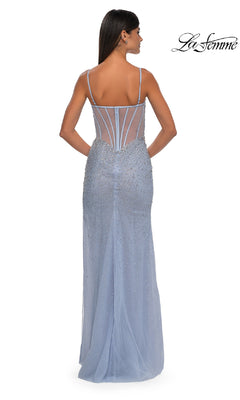 A woman faces away from the camera in the Long Beaded Prom Dress: La Femme 32840, a light blue gown with thin straps, sheer back paneling, and sparkling beaded embellishments.