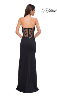 Woman models the Asymmetrical Strapless Prom Gown: La Femme 32849, featuring a sheer structured bodice and fitted long skirt, shown from the back. "La Femme" logo appears in the top right corner.