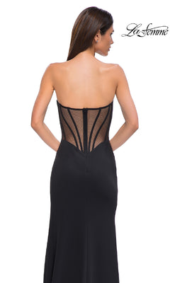 Woman wearing the Asymmetrical Strapless Prom Gown, La Femme 32849, featuring a sheer mesh back and visible boning, poses against a white background. The "La Femme" logo appears in the top right corner.