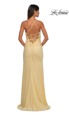 Woman in the La Femme 32851 strappy-back long prom dress in light yellow, featuring a lace-up crisscross back, stands against a white background.