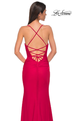 A woman wears the Strappy-Back Long Prom Dress: La Femme 32851, a fitted red gown with a lace-up crisscross back, standing against a white background. The La Femme logo is visible in the upper right corner.
