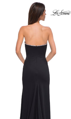 A woman models the Strapless Long Jersey Prom Dress: La Femme 32854, featuring rhinestone trim, shown from the back on a plain white background with the "La Femme" logo in the top right corner.