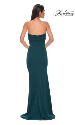 A woman models the La Femme 32863 Strapless Sweetheart Prom Gown in dark teal, featuring a fitted silhouette, floor-length skirt, and small train. The gown is shown from the back with the "La Femme" logo in the top right corner.