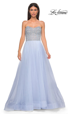 A woman models the Strapless Long Prom Ball Gown: La Femme 32875, featuring a fitted, beaded bodice and flowing light blue tulle skirt, against a plain white background.