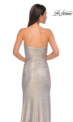 A woman models the Bodycon Long Metallic Prom Dress: La Femme 32876, featuring a strapless design, subtle sweetheart neckline, and ruched back detail, set against a white background with the "La Femme" logo in the top right corner.