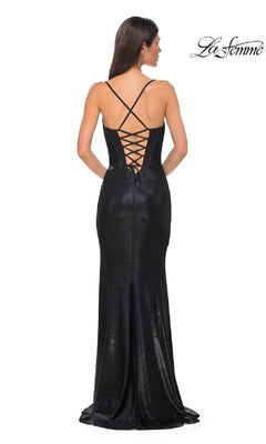 A woman wears the La Femme 32877 Lace-Up Long Metallic Prom Dress, featuring a fitted black silhouette, lace-up back with thin crisscross straps, subtle metallic sheen, and a slight train as she poses with her back to the camera.