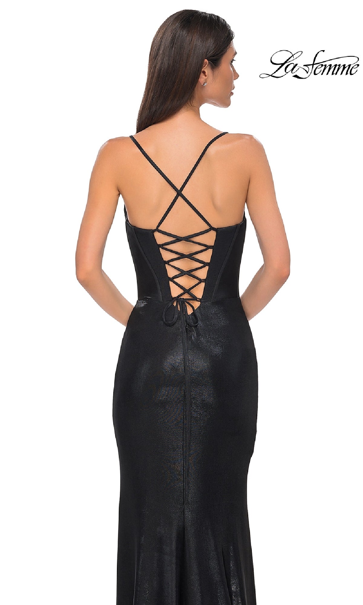 A woman stands facing away, wearing the fitted black La Femme 32877 Lace-Up Long Metallic Prom Dress with crisscross lace-up detailing on the open back. The La Femme logo is in the top right corner of this designer dress image.