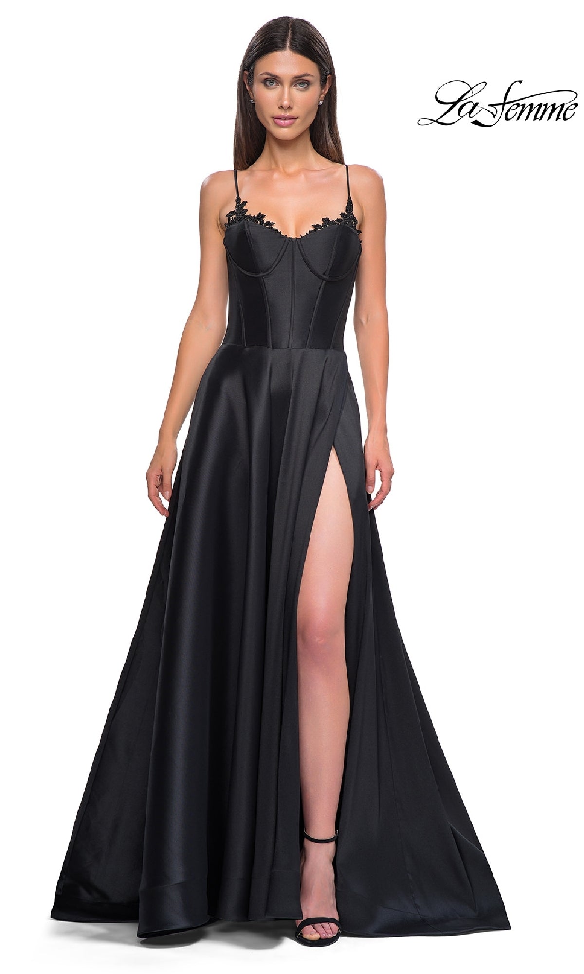 A woman models the Lace-Up Long Mikado Prom Dress: La Femme 32878—featuring a black color, spaghetti straps, lace-up back, fitted bodice, lace details, and a high side slit—against a plain white background.
