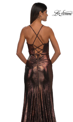 A woman stands with her back to the camera in the La Femme 32884 Lace-Up Long Metallic Prom Dress, showing off its crisscross lace-up back, thin straps, and floor-length shiny fabric.