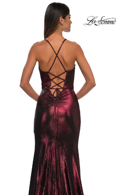Woman wearing La Femme 32884, a long metallic burgundy prom dress with crisscross lace-up back, stands with her back facing the camera. "La Femme" logo appears in the upper right corner.
