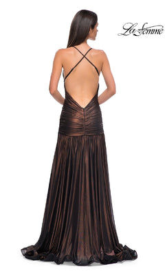 A woman models the La Femme 32887 long prom dress, featuring metallic fabric, an open back, and crisscross straps, as she stands with her back to the camera.