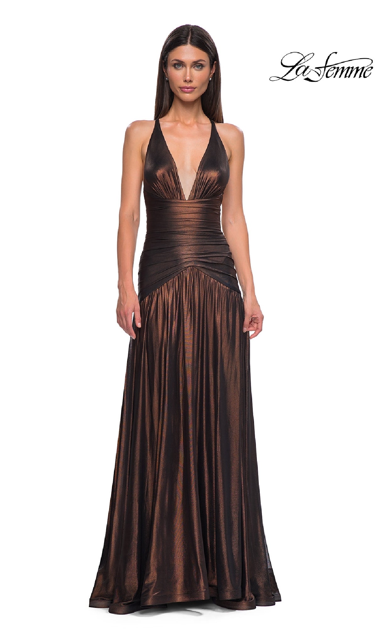 A woman wears the Long Prom Dress: La Femme 32887—a floor-length metallic gown with a deep V-neckline, fitted waist, open back, and flowing skirt. The 