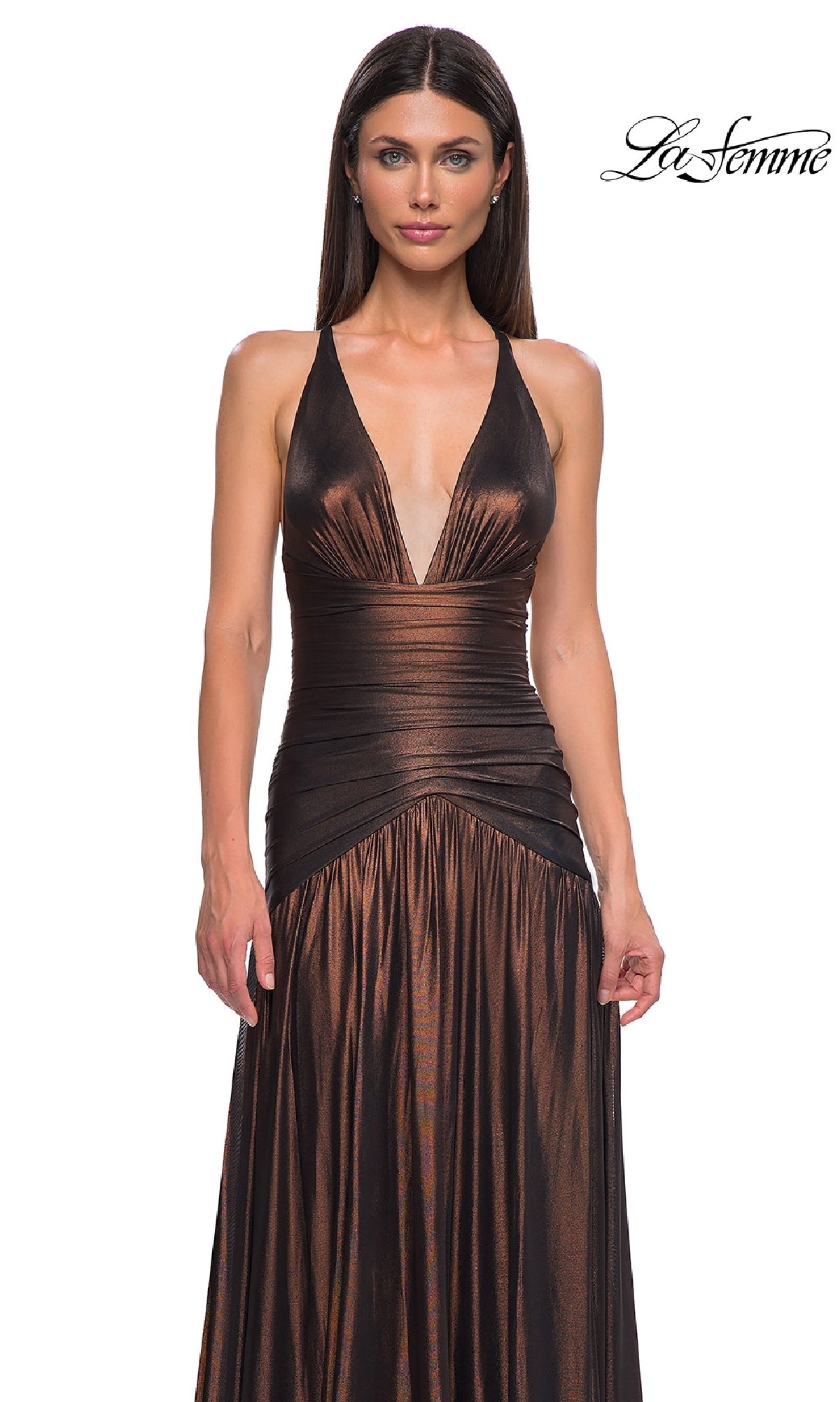 A woman models the La Femme 32887 long prom dress—sleeveless, metallic, with a deep V-neck and open back—standing before a plain white background. The 