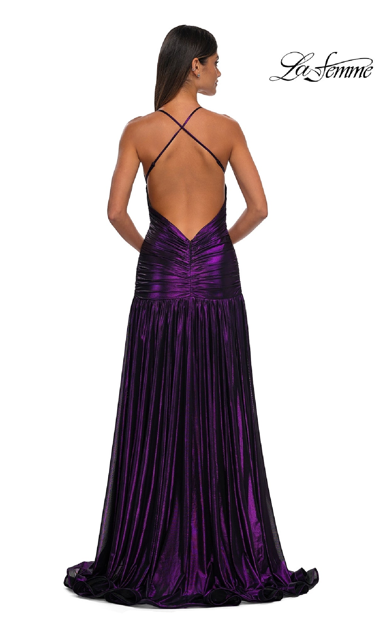 Woman models the La Femme 32887 long prom dress—a shiny, floor-length purple metallic gown featuring crisscross straps and an open back. The 