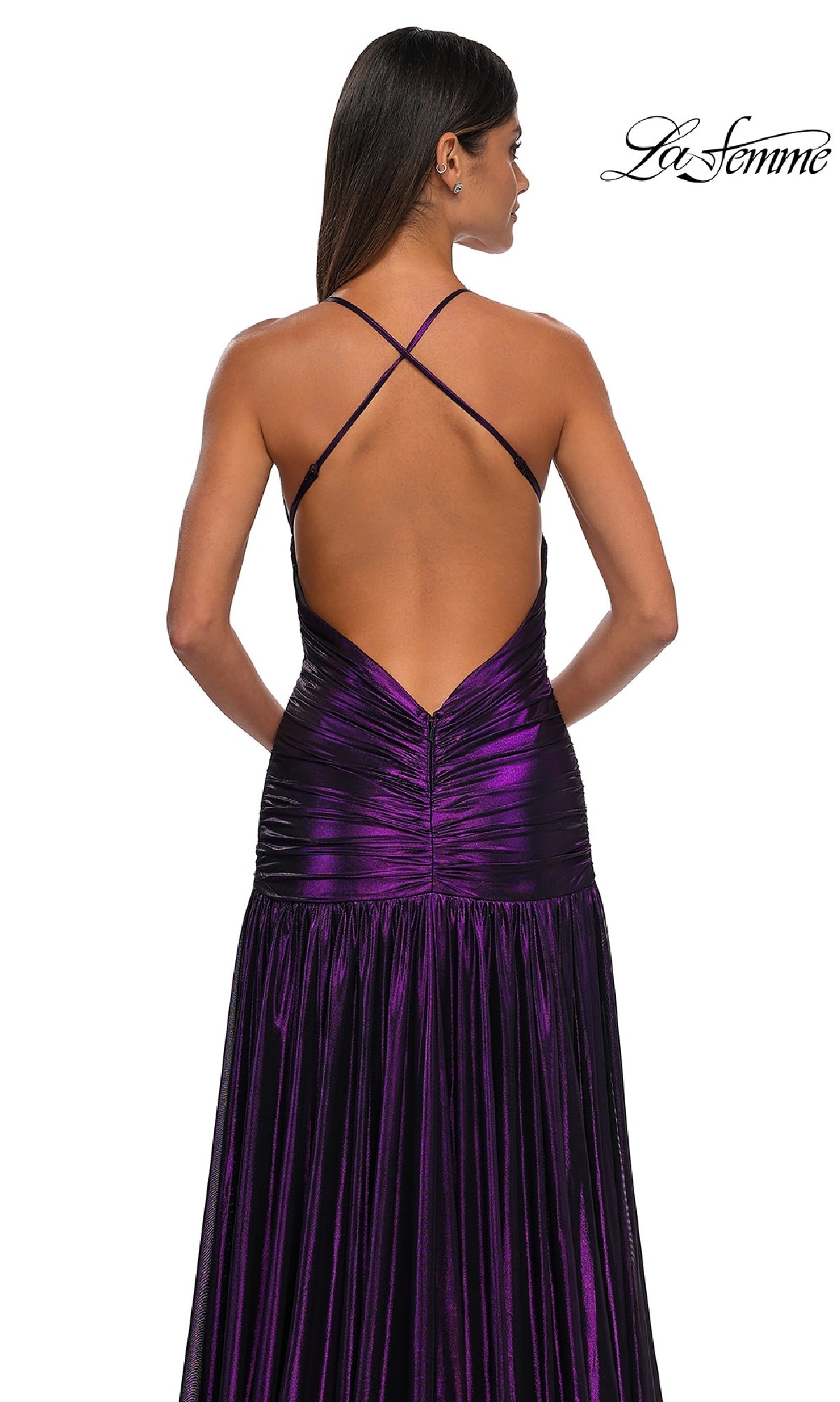 A woman faces away in the La Femme 32887 long prom dress, featuring a metallic finish, crisscross open back, ruched waist, and flowing skirt. The 
