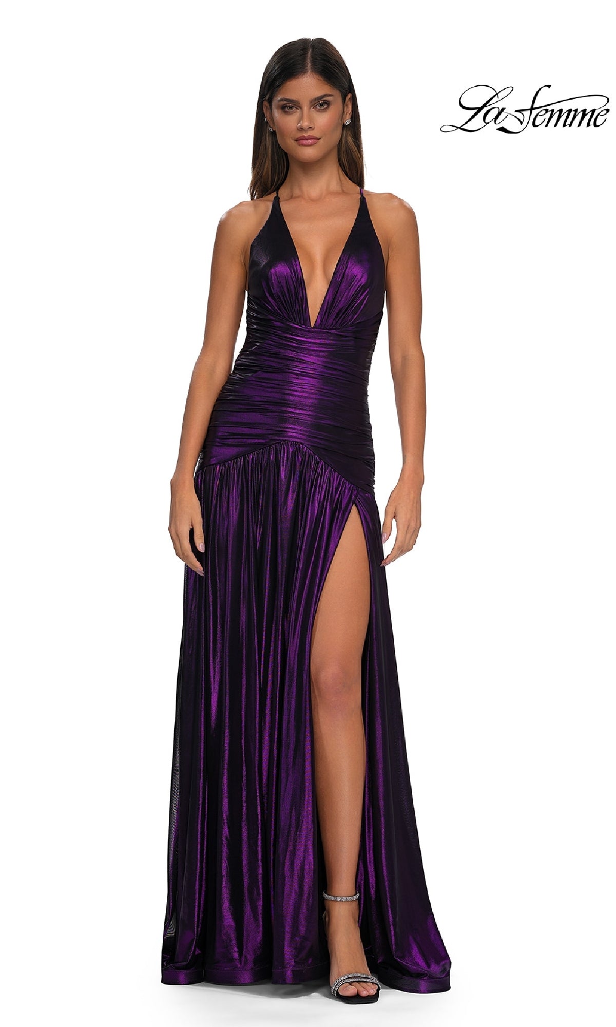 A woman models the La Femme 32887 long prom dress, featuring a sleeveless deep purple metallic design with a deep v-neckline and high slit, standing against a white background. The La Femme logo appears in the top right corner.