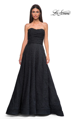 A woman models the La Femme 32893 Textured Strapless Black Prom Dress, featuring a fitted bodice and full skirt, against a white backdrop with the "La Femme" logo in the top right corner.