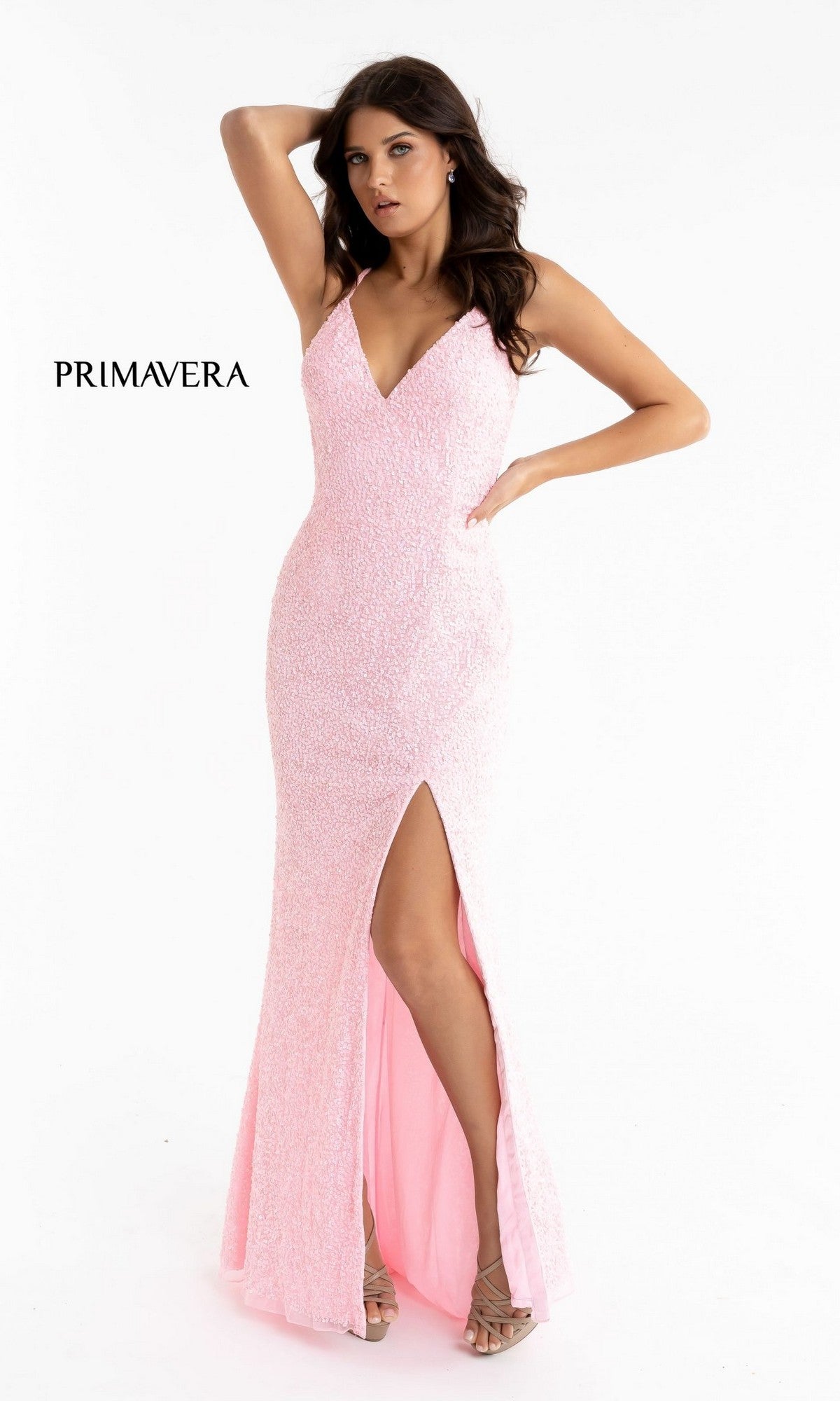 A woman poses with one hand on her head in a fitted, baby pink Deep V-Neck Long Sequin Prom Dress featuring a thigh-high slit. Ideal for formal events, 